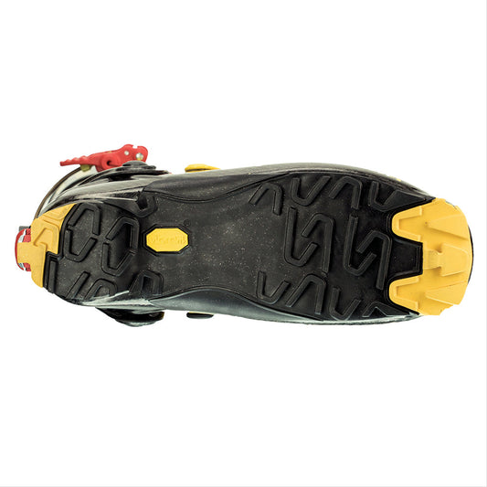 The image shows the sole of La Sportiva Stratos Hi-Cube Boots, with rugged tread, yellow Vibram branding, and yellow heel and toe accents—reflecting enhanced traction and durability inspired by lightweight ski boots with carbon construction.