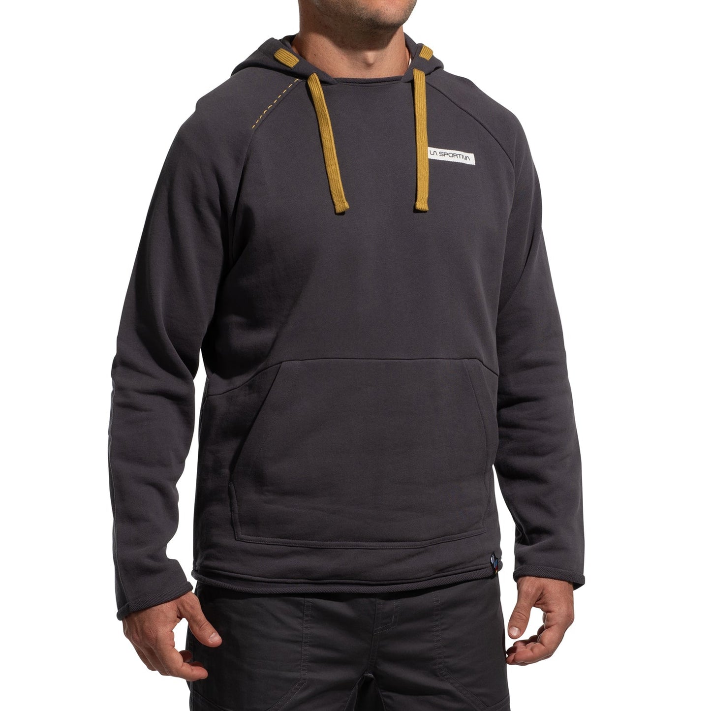 A person wears the La Sportiva Telendos Hoody Men's (2025) in dark gray, featuring yellow drawstrings, a front pocket, and a small white chest logo, paired with dark pants. The head is not visible.