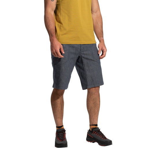 A man stands against a white background, wearing La Sportiva Sierra Rock Shorts Men's (2025) in lightweight blue for comfort, paired with a yellow t-shirt and black hiking shoes with red laces. His head is not visible.