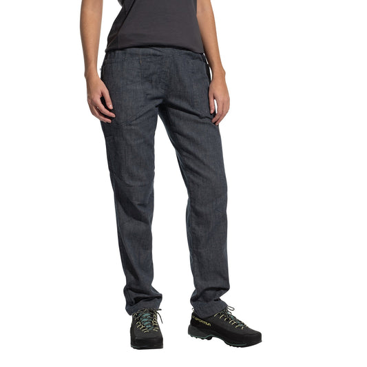 A person models La Sportiva Sierra Rock Pants Women's in dark gray, paired with a dark t-shirt and black hiking shoes with light blue laces, standing against a plain white background. Only the lower body is visible; head and upper torso are not shown.