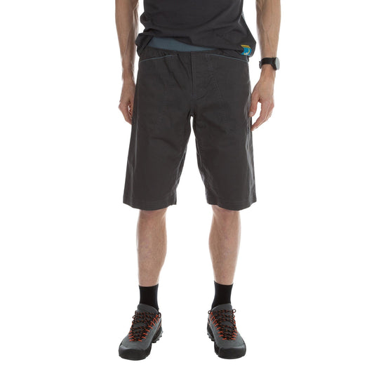 A man wearing La Sportiva Flatanger Shorts Men's (2023) in dark grey, paired with black socks and grey hiking shoes with orange laces.