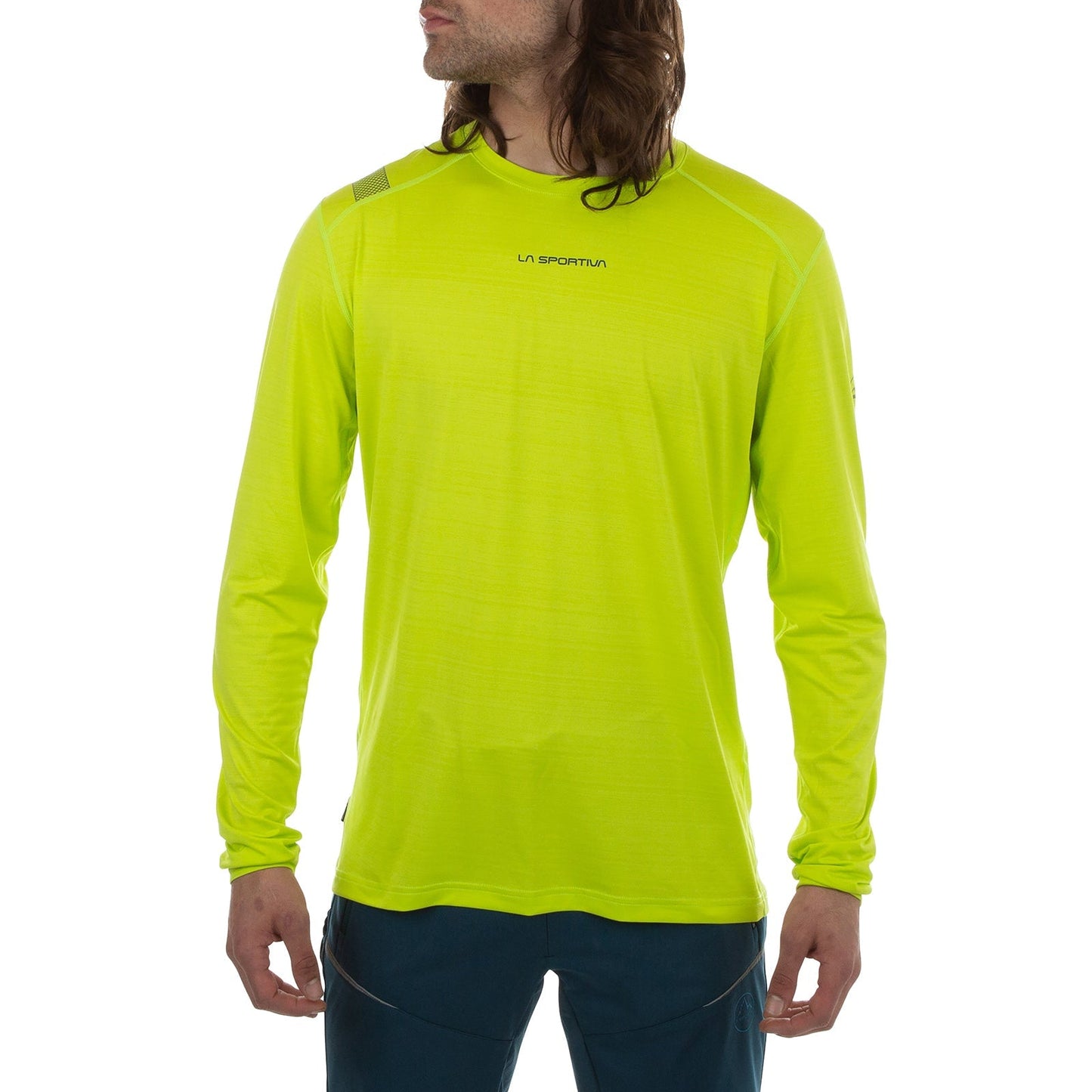 A person with long hair wears the La Sportiva Tour Long Sleeve Men's shirt in bright yellow-green with reflective details and dark pants, standing against a white background, facing forward and turning their head slightly to the side.