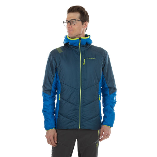 A man wearing glasses and a blue La Sportiva Mythic Primaloft Jacket stands against a white background. The jacket features PrimaLoft Silver Eco insulation and green accents. He looks slightly to the side.