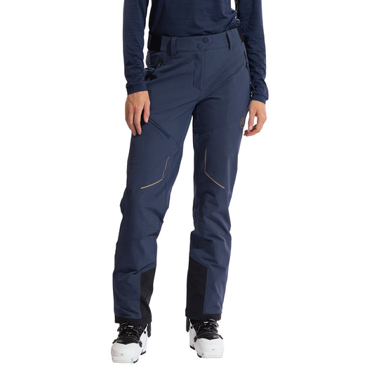 A person wearing La Sportiva Excelsior Pants Women's in navy blue and white ski boots stands against a white background, showing only the lower half—ideal apparel for ski-touring or mountaineering.