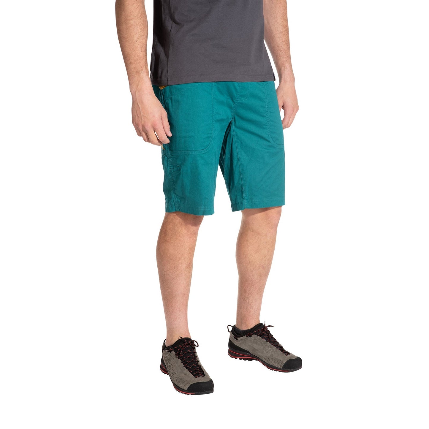 A person stands against a white background wearing La Sportiva Bleauser Shorts Men's in teal organic cotton with a gusseted crotch, paired with a gray t-shirt and gray hiking shoes. The model’s head is not visible. Ideal for bouldering sessions.