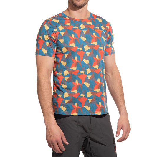 A man in a La Sportiva Dimension T-Shirt Men's (2025)—featuring colorful geometric patterns and quick-drying recycled polyester—paired with dark pants stands against a white background, his head slightly out of frame.