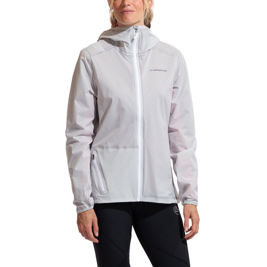 A woman wearing the La Sportiva Ethereal Pro Jacket Women's in light gray—an ultralight, three-layer shell with a hood, front zipper, subtle left chest branding, and zippered pockets—stands against a white background in black pants.