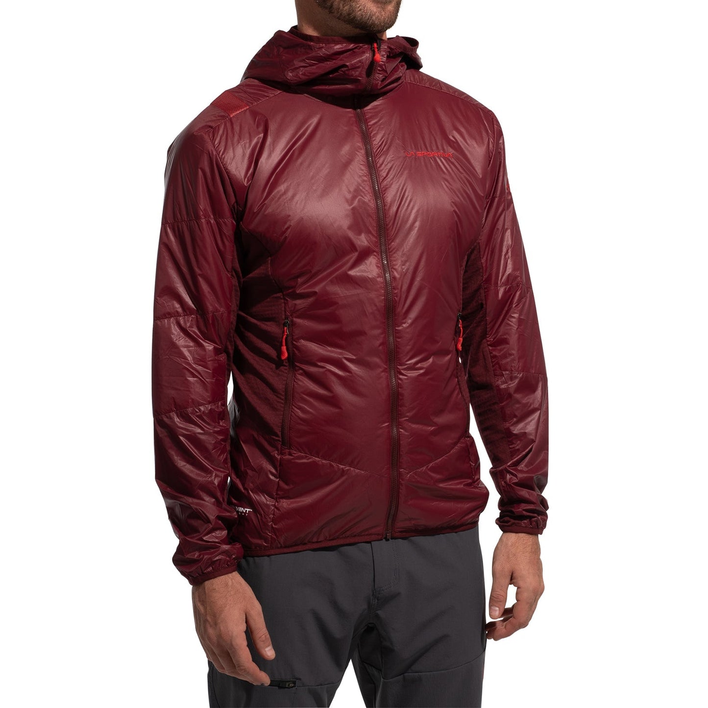 A person wearing the La Sportiva Aequilibrium Lite Insulation Jacket Men's (2025), a shiny maroon Pertex Quantum slim-fit with full zip and two zippered pockets, ideal for technical climbs, paired with gray pants. Head is not fully visible.