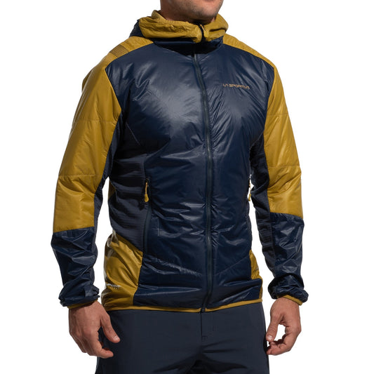 A person wears the La Sportiva Aequilibrium Lite Insulation Jacket Men's (2025), featuring navy and mustard color-blocked Pertex Quantum fabric. The hooded, zip-front design with long sleeves offers lightweight durability—ideal for technical climbs.