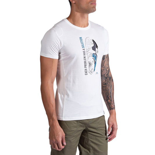 A man wears the La Sportiva Solution T-Shirt Men's, made from organic cotton with a climbing shoe graphic and "Each problem has a solution" text, paired with olive green pants. Ideal for climbers, his left arm displays a tattoo sleeve.