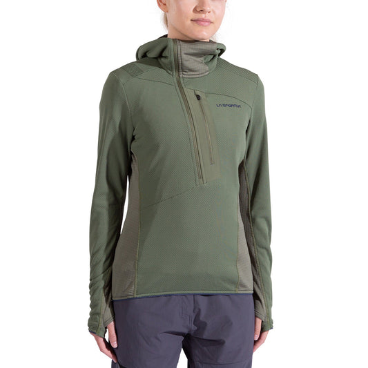 A woman in the La Sportiva Big Wall Pullover Hoody in olive green, made with TechStretch Aero Fabric and featuring zippered pockets, a high collar, and thumb holes, is paired with dark gray pants against a white background.