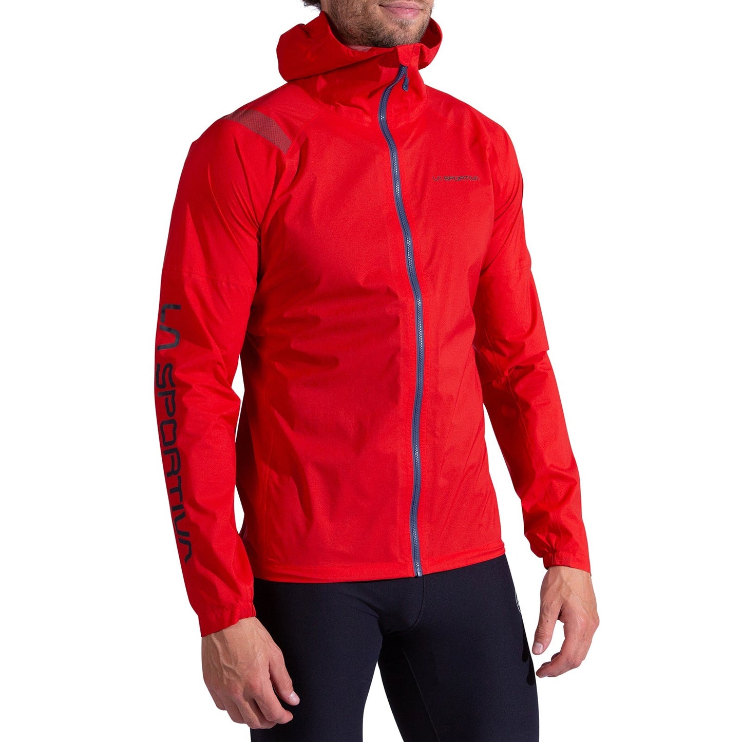 A person wears a bright red La Sportiva Pocketshell Jacket Men's with a blue zipper and logo on the left sleeve, paired with black pants. The face is partially obscured.