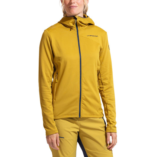 A person models the La Sportiva Cosmic Thermal Hoody Women's in mustard yellow, featuring a full zip, La Sportiva branding, and Tecnostretch Pontetorto Fabric—ideal for outdoor activities. Matching pants complete the look, with hands relaxed at their sides.
