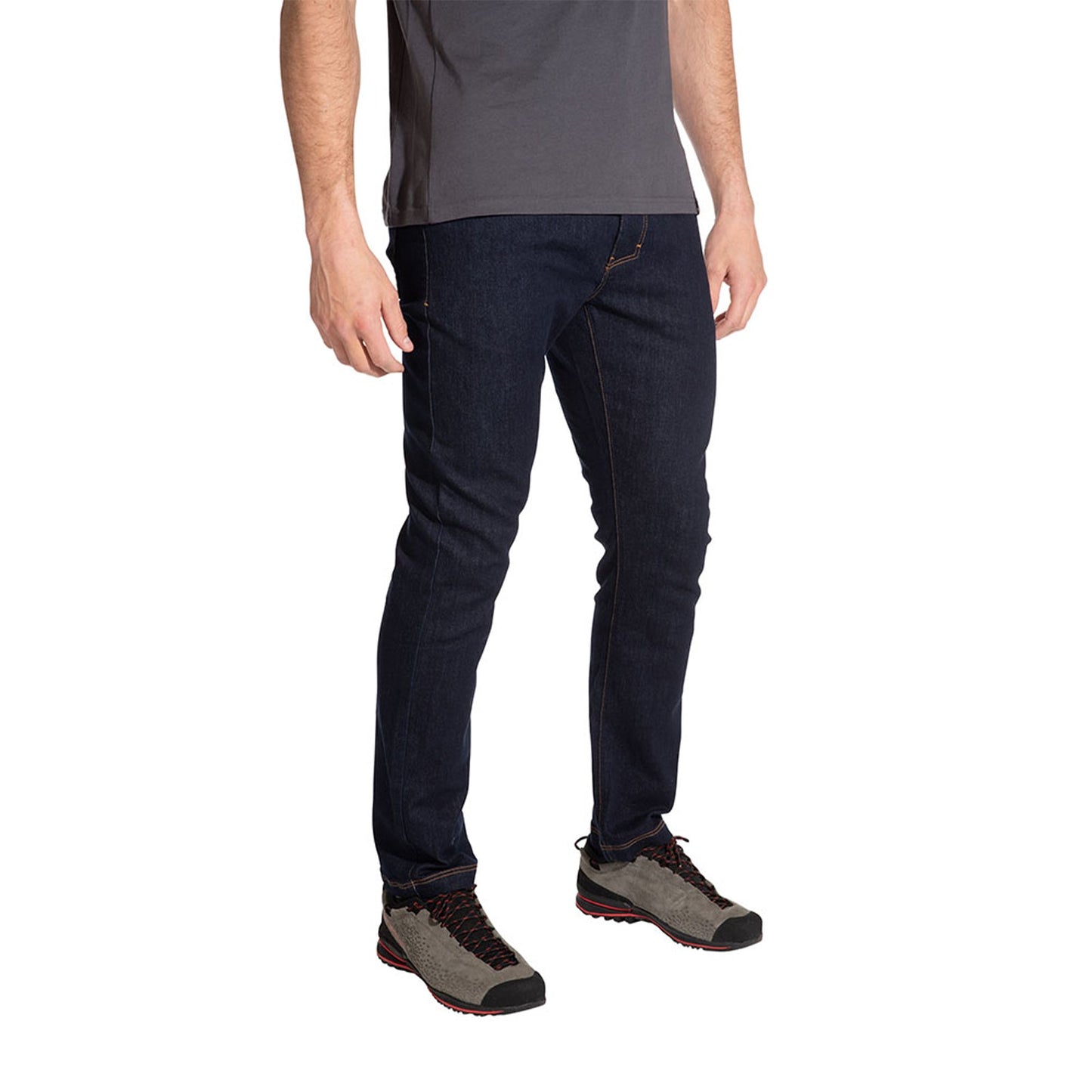 A man, shown from shoulders down against a white background, wears La Sportiva Eldo Jeans Men's with a grey t-shirt and gray hiking shoes featuring red accents.