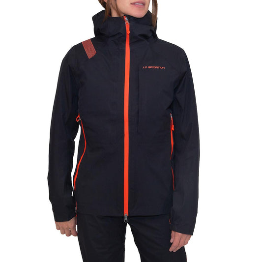 A person wearing a black La Sportiva Crizzle EVO Shell Jacket Women's with bright orange zippers and accents stands against a white background. The winter jacket features a hood and high collar, with the person's face partially out of frame.