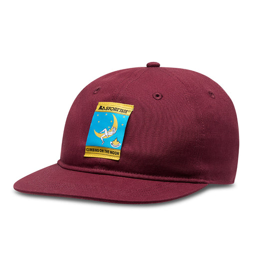 The La Sportiva Climbing On The Moon Hat (2025) is a maroon organic cotton cap featuring a climber-on-the-moon patch, the La Sportiva logo, and "CLIMBING ON THE MOON" text.