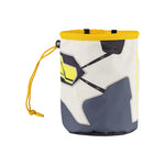 The La Sportiva Solution Chalk Bag is cylindrical with a drawstring closure and clip, showcasing a geometric grey, white, yellow, and black pattern and “SPORTIVA” printed vertically on the side.