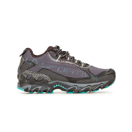 The La Sportiva Wildcat 2.0 GTX Women's (2023) is a black and gray trail runner with turquoise accents, a mesh upper, rugged sole, waterproof Gore-Tex lining, and branding on the side, shown in a side view against a white background.