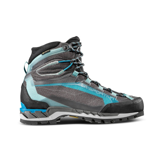 The La Sportiva Trango Tech GTX Women's is a gray and blue high-top mountaineering boot with black laces, a rugged sole, reinforced toe, and semi-automatic crampon compatibility—designed for technical mountain terrain. Shown in side profile on white.