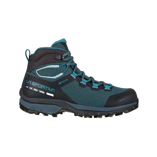 The La Sportiva TX Hike Mid GTX Women's (2023) is a blue and black, high-ankle hiking boot with a textured sole, partially made from recycled materials, featuring La Sportiva branding on the side, shown on a white background.