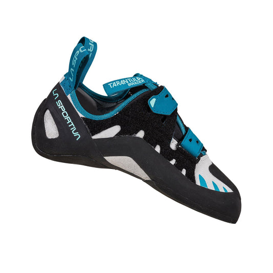 The La Sportiva Tarantula Boulder Women's climbing shoe in black, teal, and white features Velcro straps, robust toe rubber for bouldering, a durable sole, and branding on the heel and tongue, shown on a white background.