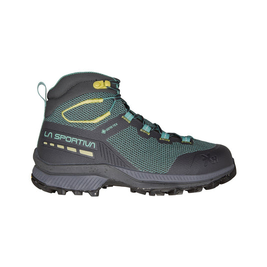 The La Sportiva TX Hike Mid GTX Women's hiking boot in dark gray with teal and yellow accents features mesh panels, a recycled Gore-Tex membrane, rugged outsole, and high-ankle design, shown in side profile on a white background.