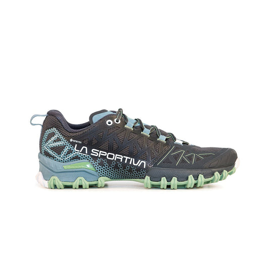 The La Sportiva Bushido II GTX Women's trail running shoe features black and teal colors with green accents, a rugged traction sole, mesh upper, and geometric side patterns, shown in side profile on a white background.