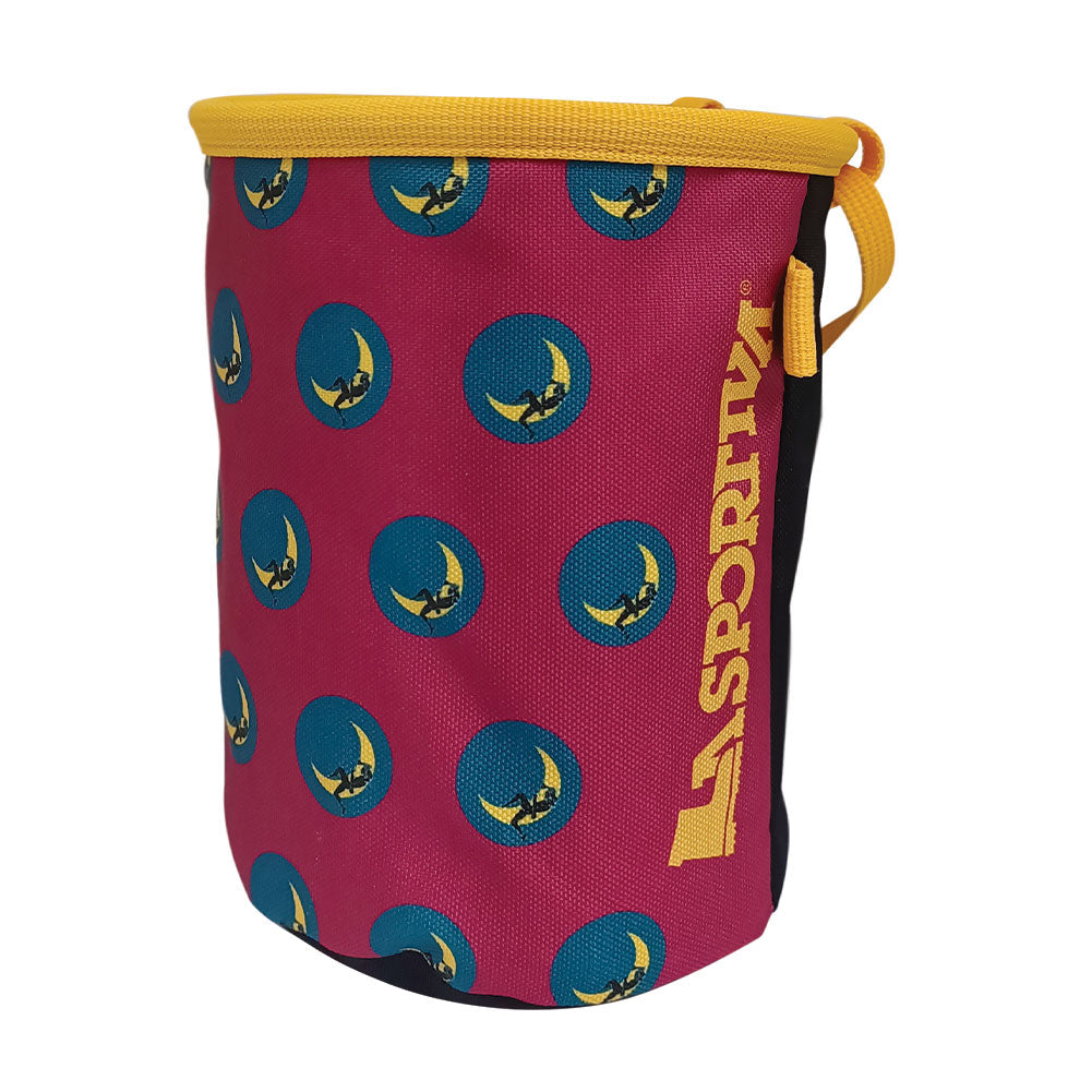 The La Sportiva Climbing On The Moon Chalk Bag is a cylindrical pink chalk bag with blue circles, yellow logo patterns, yellow trim and carrying loop. The vertical La Sportiva name embodies the Climbing on the Moon spirit.