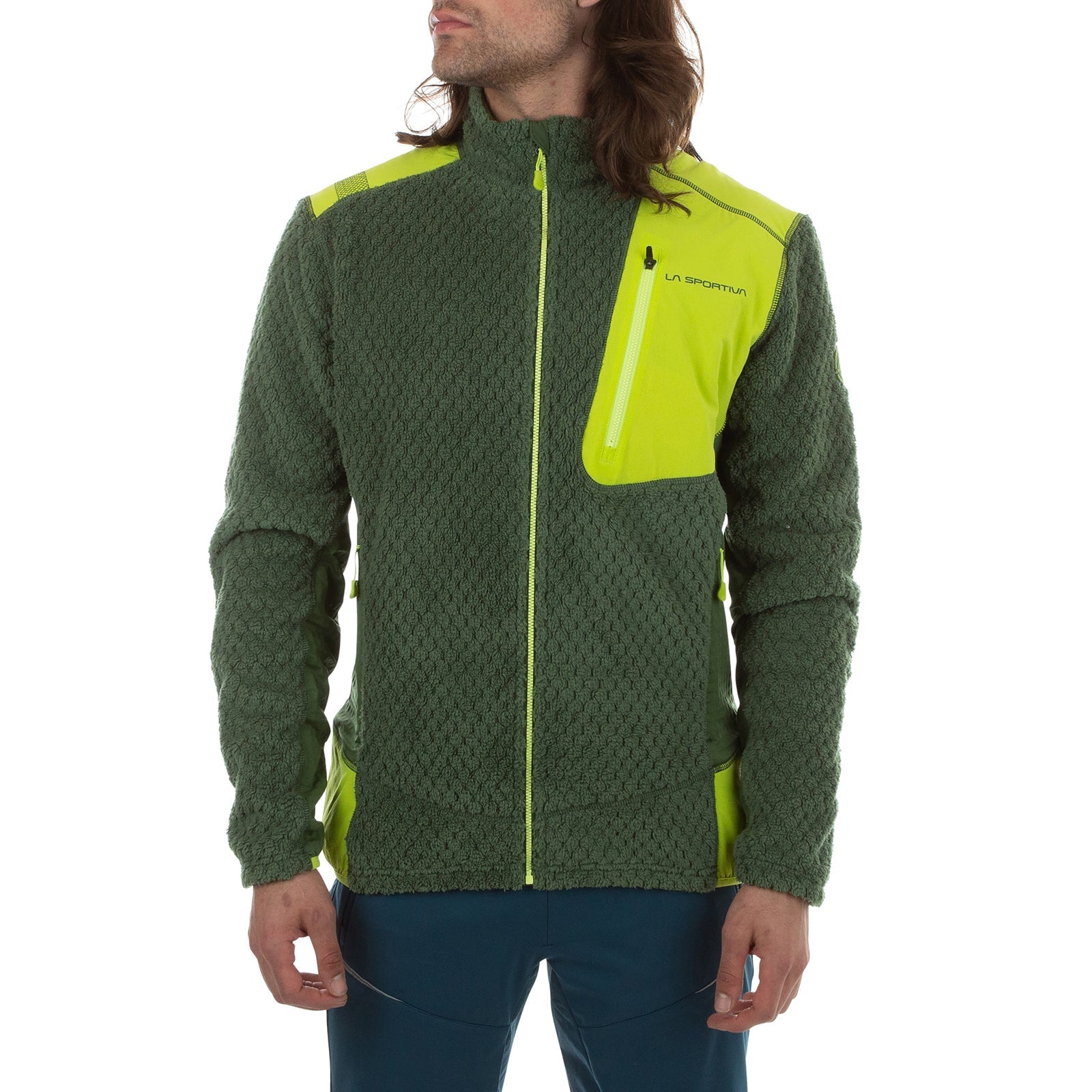 A person wears the La Sportiva Bristen Thermal Jacket Men's—a textured green insulating jacket with bright yellow accents, zippers, high collar, and a zippered chest pocket. They stand with hands relaxed by their sides; their face is partially visible.