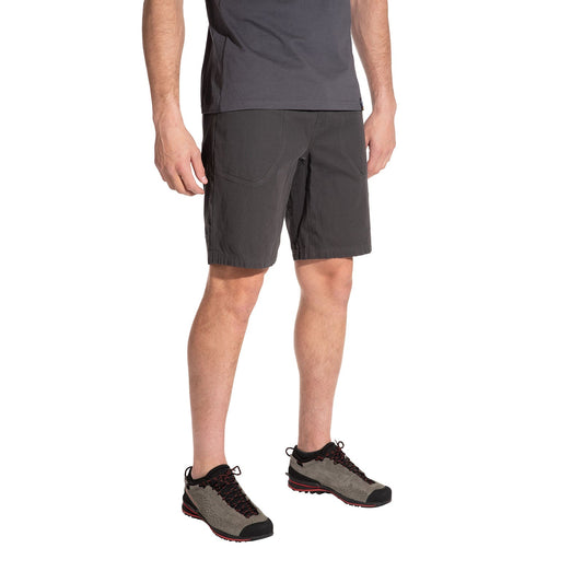Wearing La Sportiva Flatanger Shorts Men's and gray hiking shoes with black and red accents, a person stands against a white background. Only the lower body is visible, emphasizing the shorts’ design for freedom of movement.