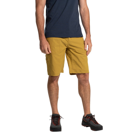 A person stands against a white background wearing La Sportiva Talus Shorts Men's (2025) in mustard yellow recycled fabric, a navy t-shirt, and black hiking shoes with red accents; the image is cropped at the shoulders.