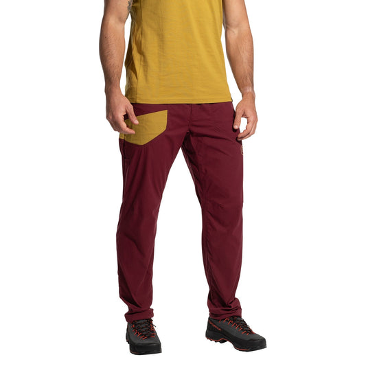 A person stands facing forward against a white background, wearing La Sportiva Labyrinth Pants Men's (2025) in maroon with a mustard pocket and adjustable waistband, a mustard yellow t-shirt, and black hiking shoes. The person's head is not visible.