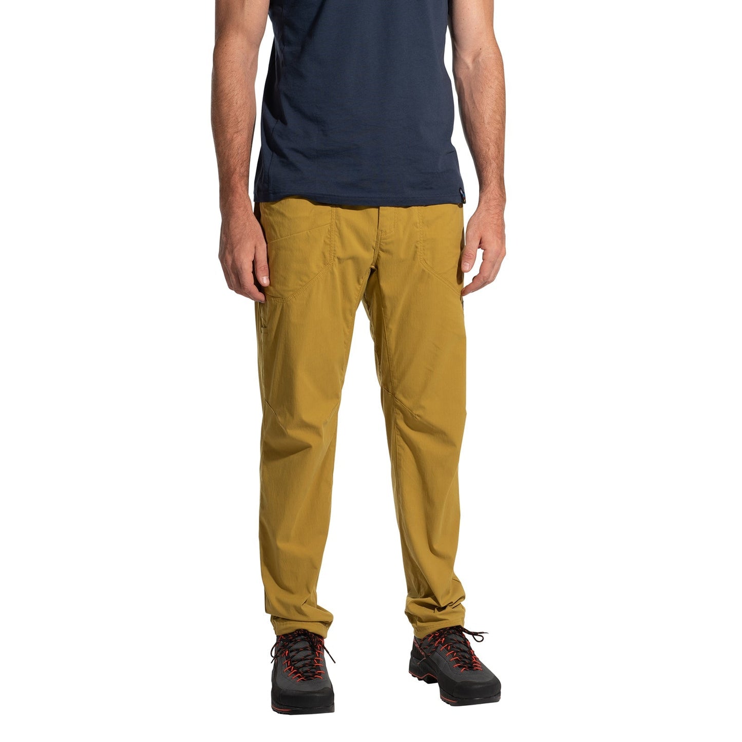 A man models La Sportiva Labyrinth Pants Men's (2025) in mustard yellow with an adjustable waistband, paired with a navy t-shirt and black hiking shoes with red laces, standing against a white background. His head is not visible.