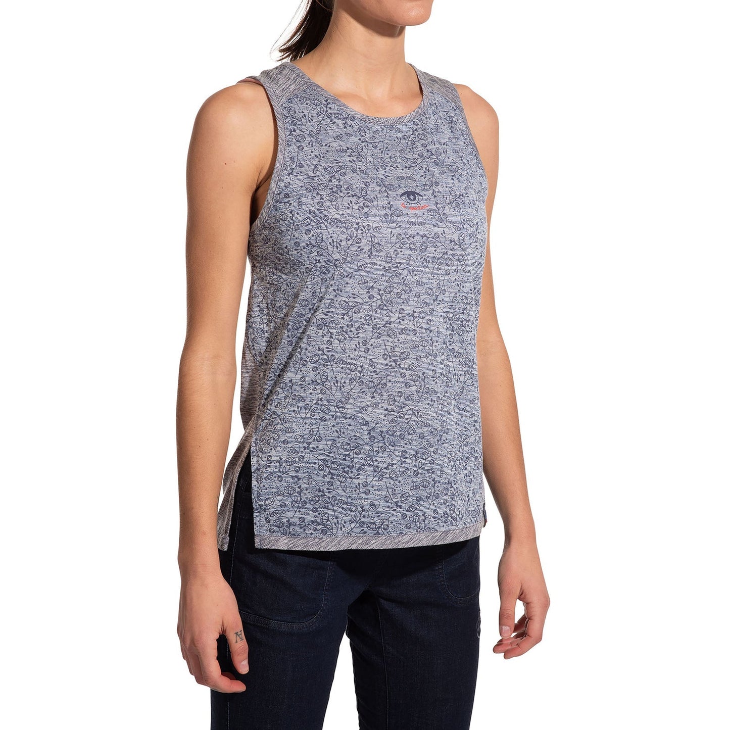 A woman models the La Sportiva Magic Tank Women's—a sleeveless, light blue patterned bamboo fabric top—with dark jeans against a white background. Her head is turned slightly aside, her face partially out of frame.