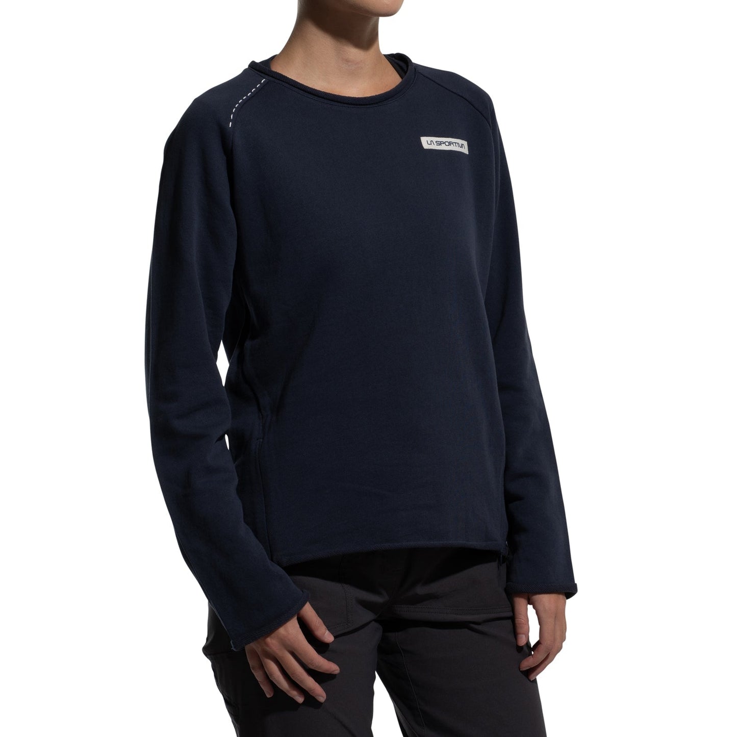 A person wearing the La Sportiva Tufa Sweater Women's (2025) in dark navy organic cotton with a small white chest logo and dark pants, standing against a plain white background.
