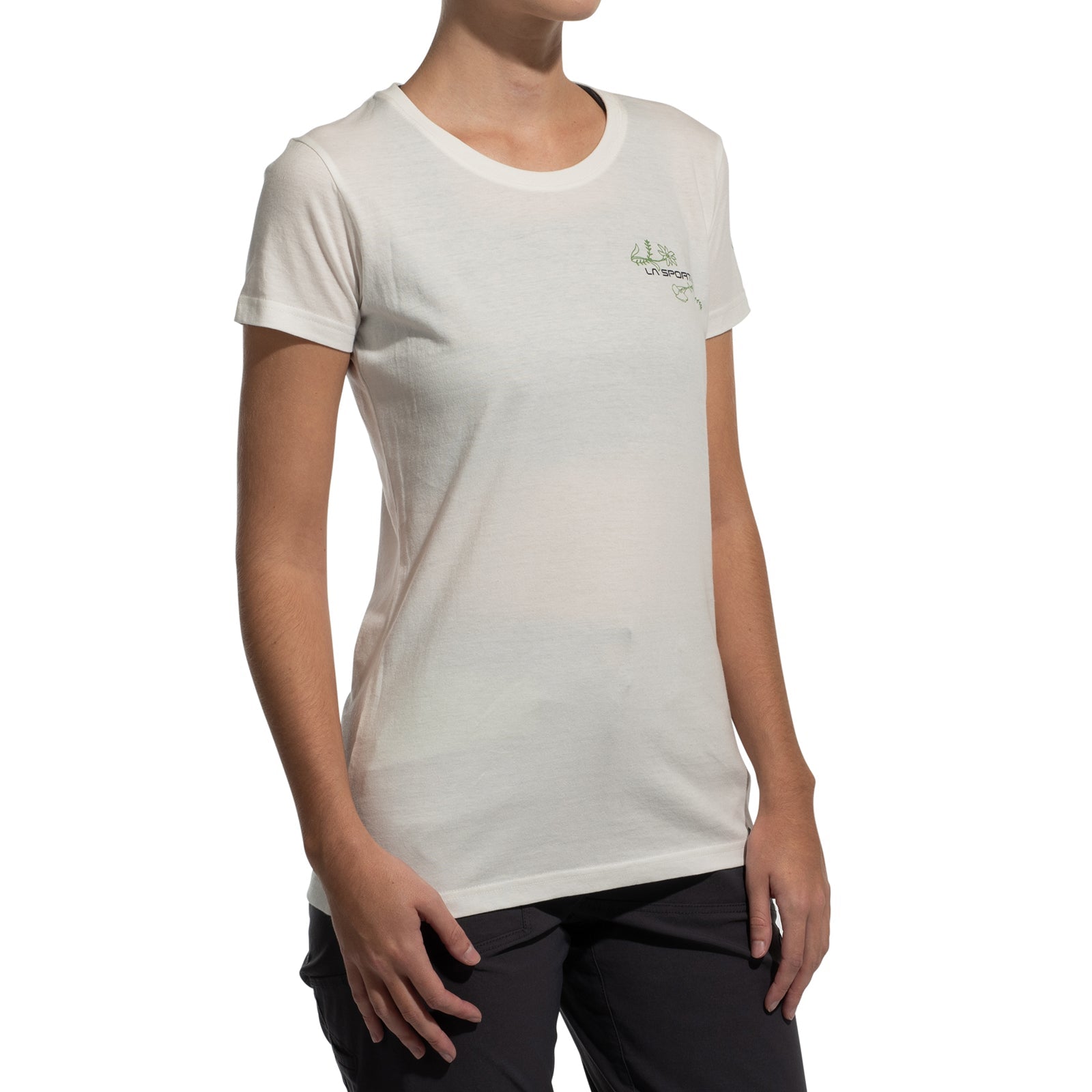 A person in the La Sportiva Climb Flower T-Shirt Women's (2025), made from organic cotton, and dark pants stands against a white background. The tee has a small design on the left chest. The person's face is not visible.