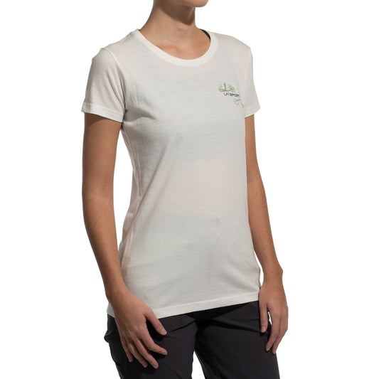 A person in the La Sportiva Climb Flower T-Shirt Women's (2025), made from organic cotton, and dark pants stands against a white background. The tee has a small design on the left chest. The person's face is not visible.