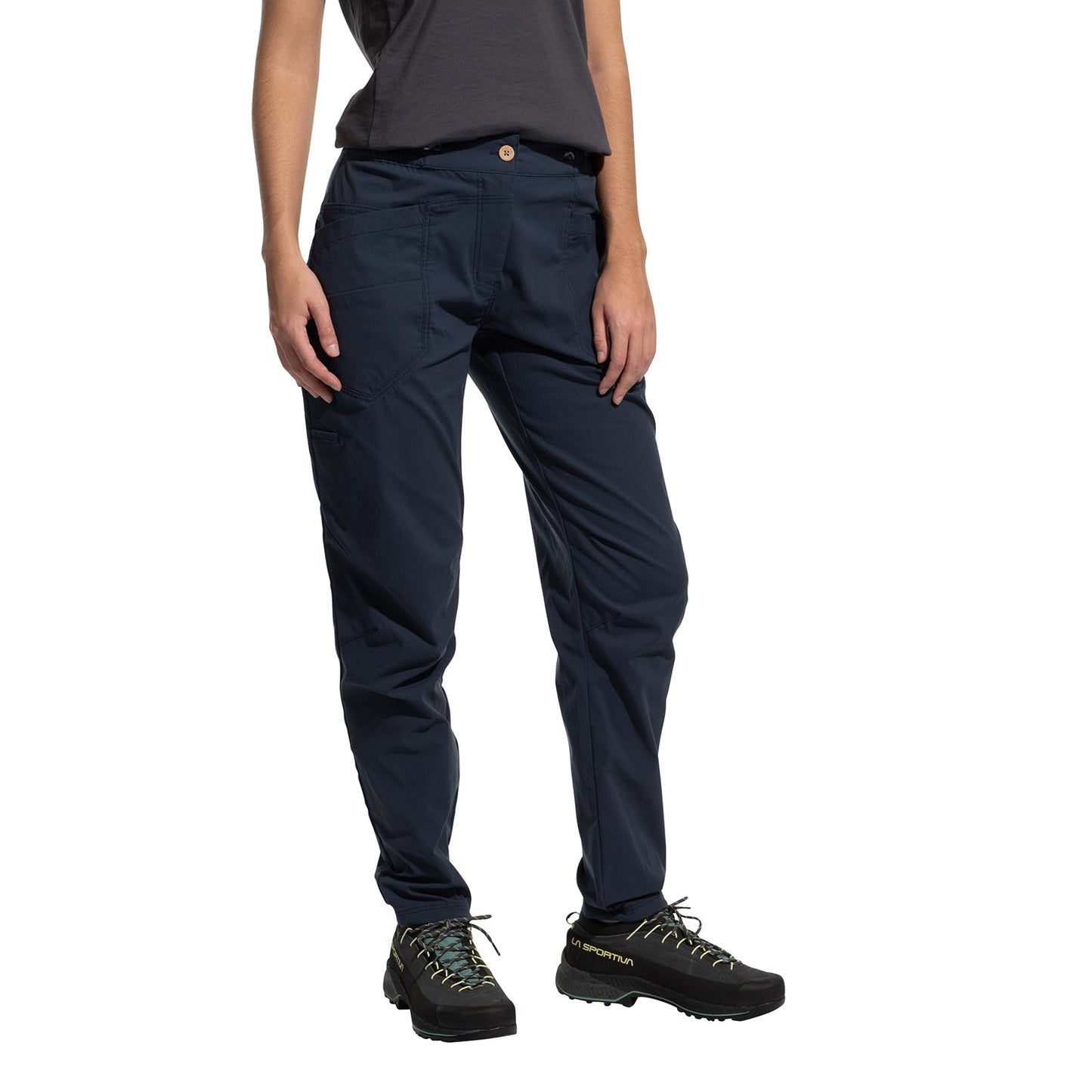 A person models La Sportiva Labyrinth Pants Women's (2025) in navy blue with an adjustable waistband, paired with a dark gray t-shirt and black hiking shoes, standing against a white background. Only the lower half is visible, arms relaxed at their sides.