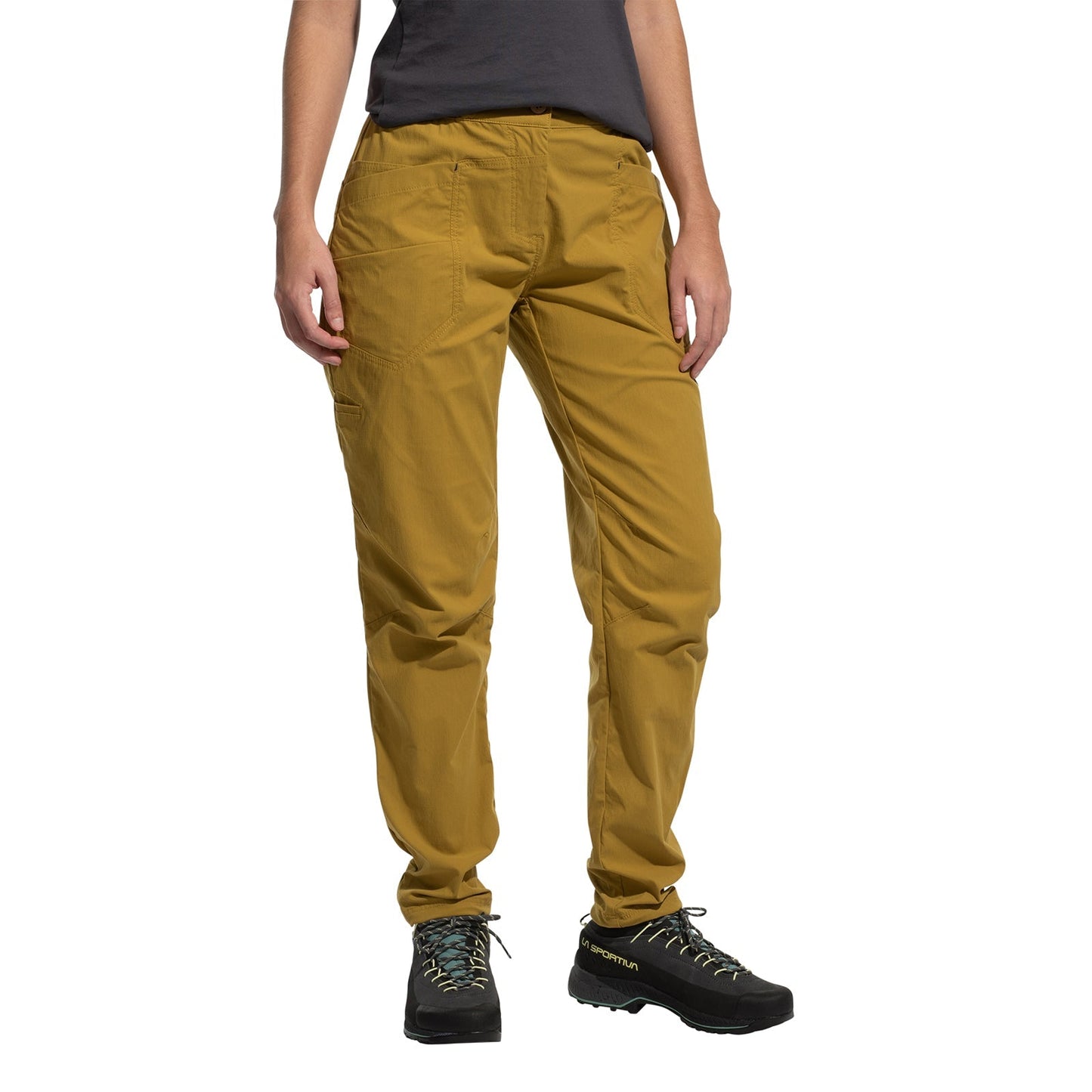 A person wearing La Sportiva Labyrinth Pants Women's (2025) in mustard yellow with an adjustable waistband, black trail shoes, and a dark gray t-shirt is shown from shoulders down against a white background.