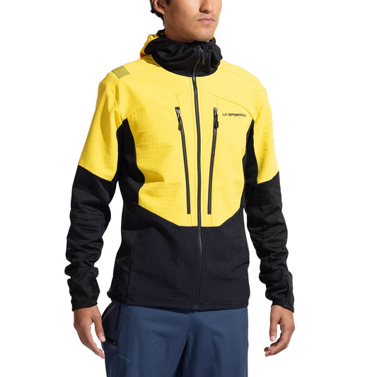 A man wears the La Sportiva Session Tech Hoody Men's in yellow and black, featuring a hood, two vertical chest pockets, and branding. Made from recycled materials, he stands against a white background.