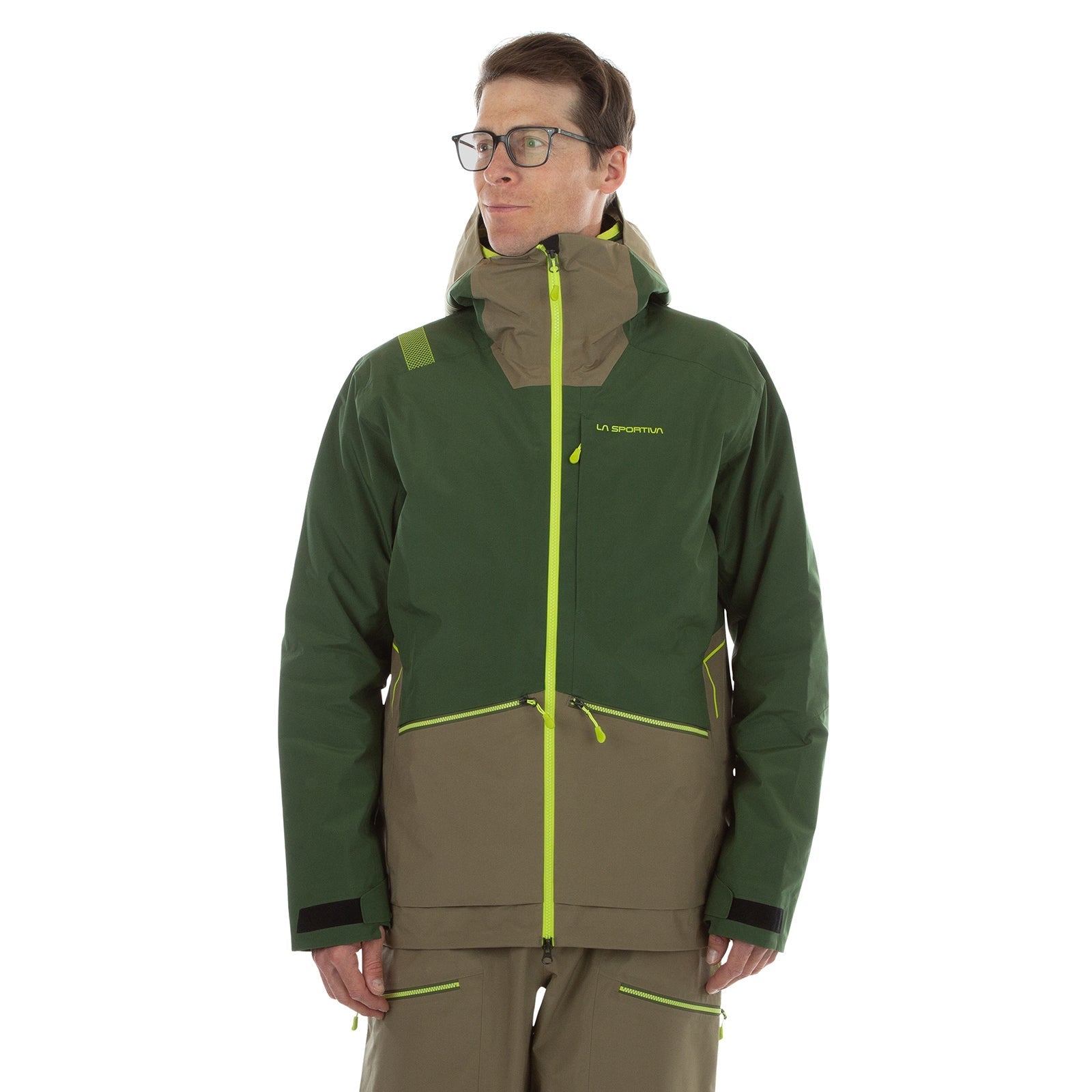 A man wearing glasses models the La Sportiva Chaser EVO Shell Jacket Men's, a two-tone green and brown outdoor jacket with yellow zippers, underarm ventilation, hood, and La Sportiva branding, against a plain white background.