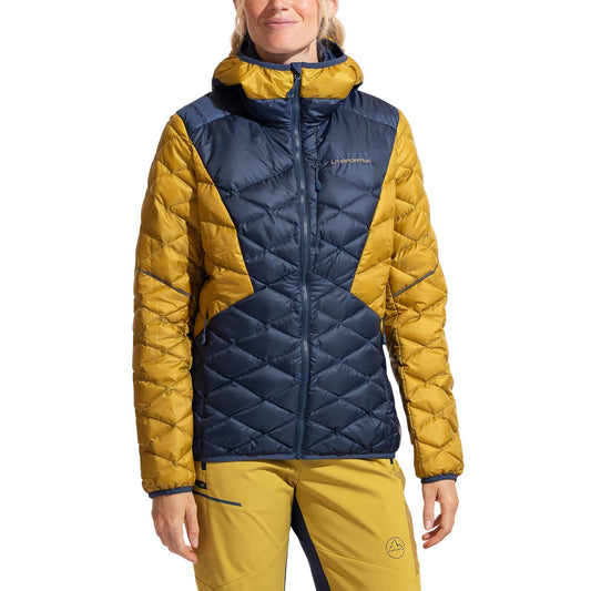 A woman stands facing forward against a white background wearing the La Sportiva Pinnacle Down Jacket in blue and yellow with an adjustable hood, paired with matching yellow pants.