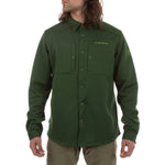 A person wears the La Sportiva Spacer Shirt Men's in olive green, a long-sleeve top made with recycled materials and featuring the La Sportiva logo on the chest and sleeve, standing with arms relaxed and head slightly turned.