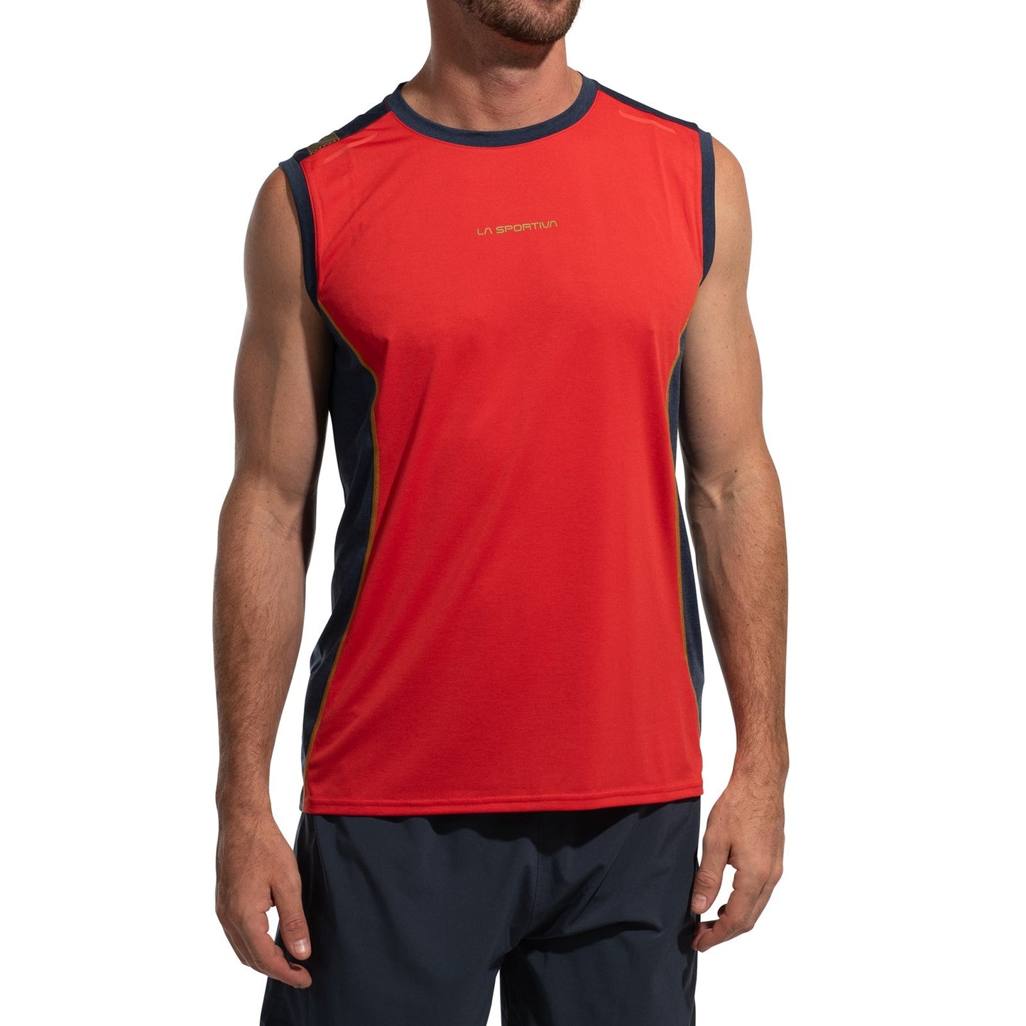 A man stands facing forward against a white background, wearing a La Sportiva Tracer Tank Men's in red with dark side panels and navy shorts, highlighting its moisture-wicking performance.