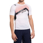 A man stands against a white background in the La Sportiva Wave T-Shirt Men's— a breathable, white running shirt with red and black diagonal stripes and "LA SPORTIVA" on the chest—paired with dark athletic shorts.