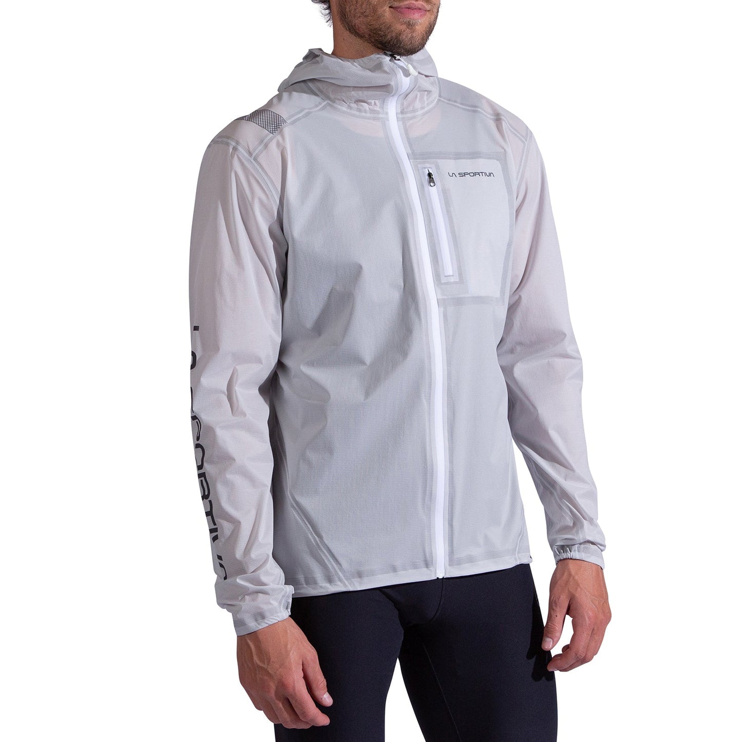 A man wears the La Sportiva Ethereal Pro Jacket Men's, a lightweight white zip-up with a hood and La Sportiva logos on the chest and sleeve, designed for freedom of movement with its three-layer shell, paired with black pants.
