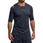 A man wears the La Sportiva Trail Bite T-Shirt Men's in dark blue, featuring short sleeves, a subtle pattern, and gold La Sportiva text on the chest. The moisture-wicking fabric is ideal for trail running. His head is not visible in the image.