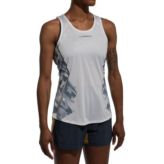 A woman in a white La Sportiva Pacer Tank Women's, featuring gray side patterns and made from recycled polyester, paired with black and yellow running shorts, stands against a white background.