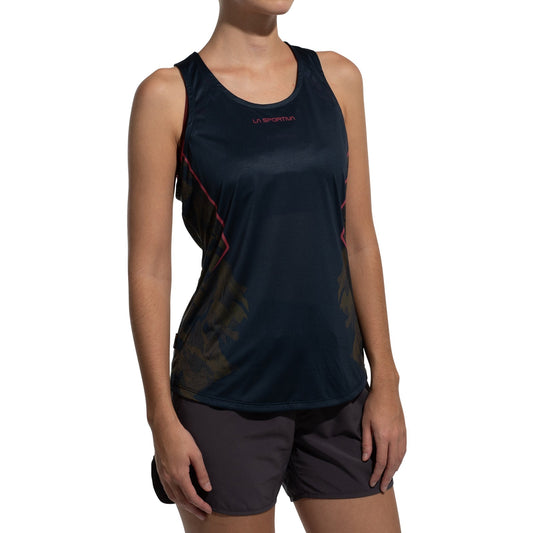 A woman models the La Sportiva Pacer Tank Women's, a sleeveless black top with red accents made from recycled polyester, paired with dark shorts. She stands against a plain white background; her face is not visible.
