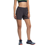 A person wearing La Sportiva Sudden Shorts Women's stands against a white background. The cropped athletic top and trail running shoes are visible, but the person's head is not shown in the image.